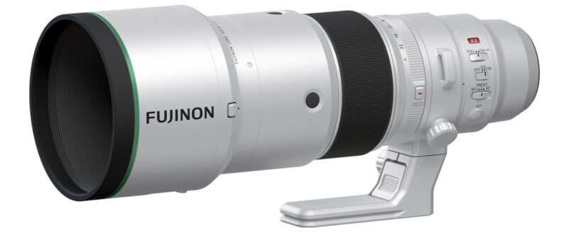 A white Fujinon camera lens with a large front element, marked with branding and a green ring. The lens features various controls and a tripod mounting foot, designed for use with professional photography.