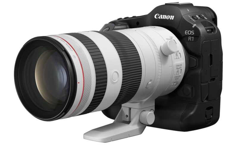 A Canon EOS R1 camera with a large zoom lens attached, featuring a black body and white lens with a red ring. The camera is positioned facing left, highlighting the detailed design and features of the lens and camera body.