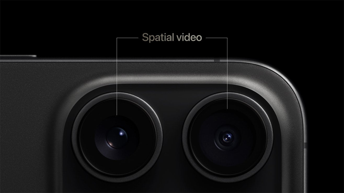 Close-up of a smartphone's dual camera lenses, labeled "spatial video" against a dark background. The lenses are housed in a sleek, rounded rectangular module.