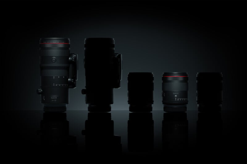 A dramatic image showcasing five camera lenses of varying sizes in a dark setting. The lenses have a sleek design with red accents and are arranged in a line from tallest to shortest against a reflective surface.