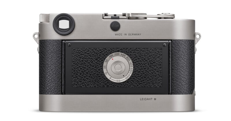 Rear view of a Leica M Edition 60 camera showing the ISO dial with a classic design. The camera has a silver finish with black textured leather, and "Made in Germany" is engraved on the top.