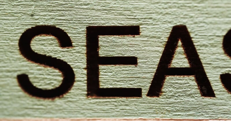 Close-up of the word "SEA" embossed in dark letters on a textured light green background.