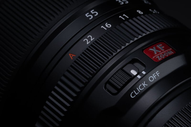 Close-up image of a black camera lens showing focus and zoom rings. The aperture is set to f/22, and a switch is labeled "CLICK OFF." The lens features the letters "XF" and "ZOOM" in red text on the barrel.