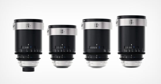 Four black and silver camera lenses of different focal lengths are arranged side by side against a white background. Each lens features blue focus and aperture markings.