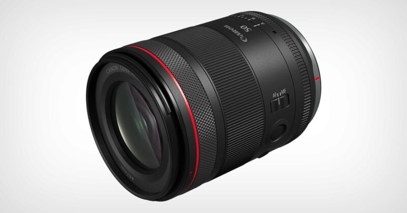 A black camera lens with red and silver accents is displayed against a white background. The lens features detailed markings and switches for settings adjustments.