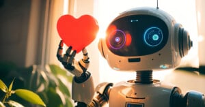 A small robot with glowing eyes holds a red heart shape with one hand, standing in a softly lit room with plants. Sunlight streams through a window in the background, creating a warm and inviting atmosphere.