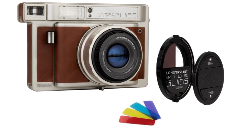 A vintage-style instant wide glass camera with brown accents is displayed alongside a lens cap, a splitzer accessory, and four colorful lens filters in blue, yellow, red, and green.