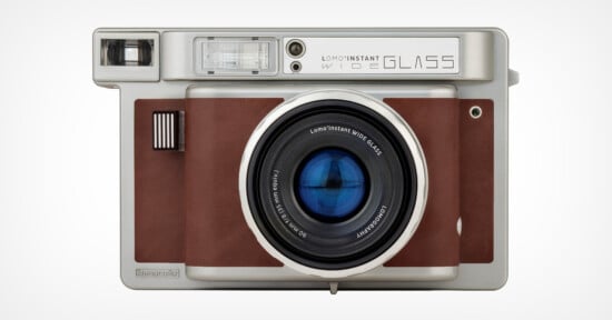 A vintage-style Lomo'Instant Wide Glass camera with a silver body, brown leather accents, and a prominent lens in the center is displayed against a plain white background.