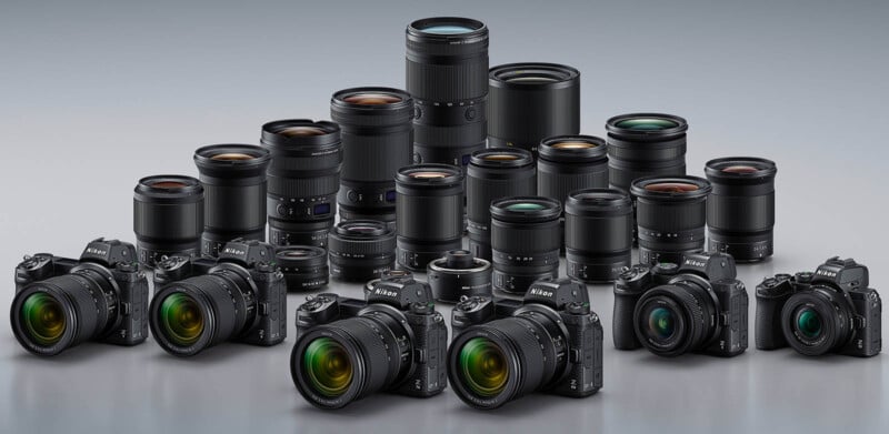 A collection of Nikon cameras and lenses arranged in rows. The setup features various models of cameras with multiple lens sizes, highlighting a range of photography equipment. The background is a neutral gray gradient.