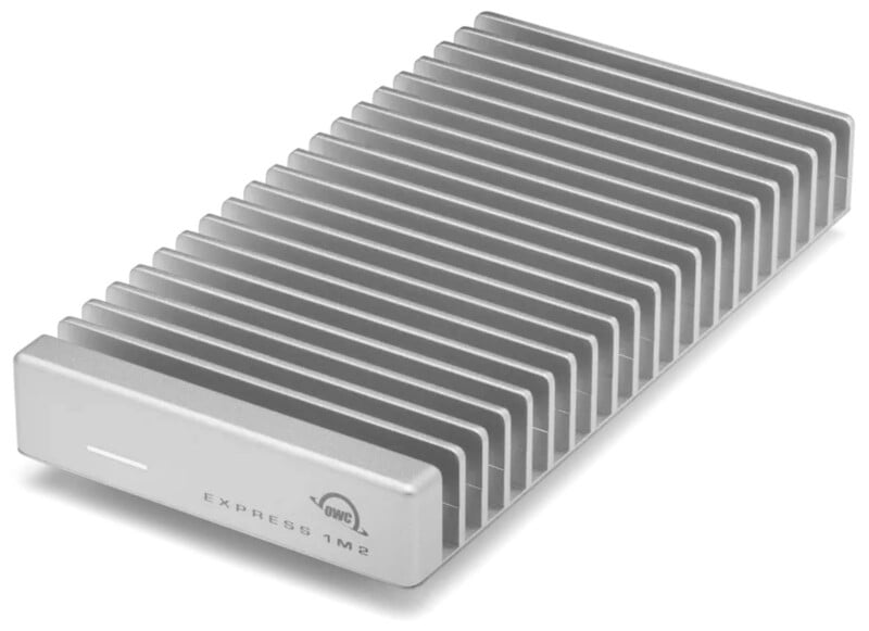 A silver external hard drive with a ridged heat sink design, labeled "OWC Express 1M2" on the front.