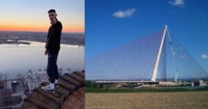 A person standing on the edge of a rooftop at sunset, overlooking a river, with their hand pointing at the camera. On the right, a modern cable-stayed bridge against a clear blue sky.