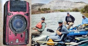 A damaged red Olympus camera with mud on it is shown on the left. On the right, four men in casual fishing gear are smiling while seated in a raft on a river, with a rocky landscape and trees in the background.