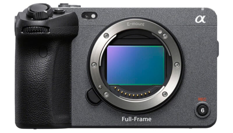 A full-frame mirrorless camera body with no lens attached, displaying the camera sensor. The camera has an e-mount and features a textured grip on the left side. The camera is metallic gray with some control buttons and dials visible.