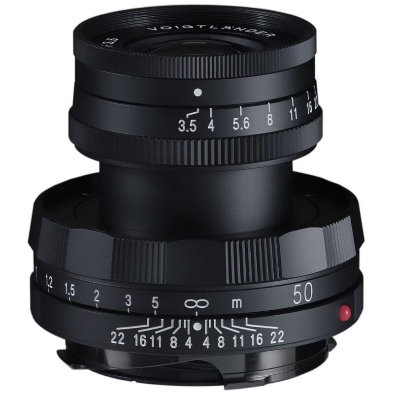 A black Voigtlander camera lens with aperture and focus rings, featuring white numeric markings for settings. The lens is positioned vertically against a plain white background.