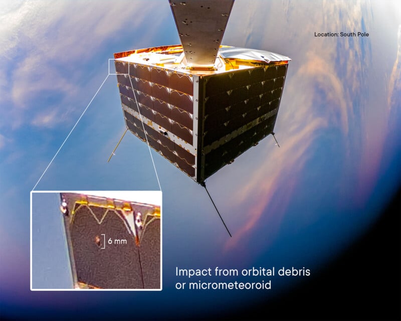 A satellite in space over the South Pole has a visible impact mark from orbital debris or a micrometeoroid. A zoomed-in inset shows a 6 mm size indication of the damage on a solar panel surface.