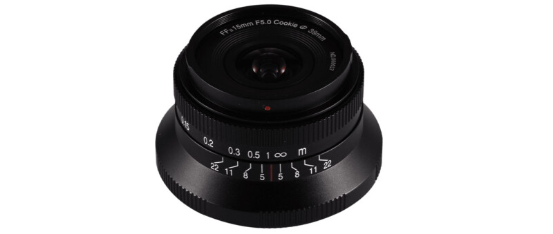 A black camera lens with a 1.5mm focal length and f/5.6 aperture, labeled "Cookie 33mm," is positioned upright against a white background.