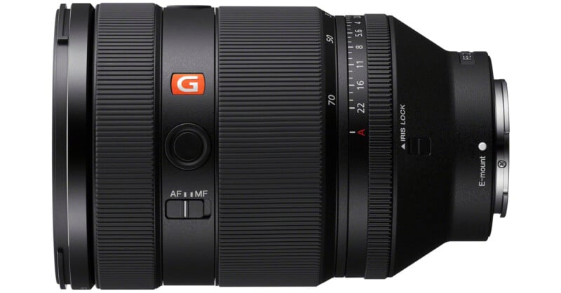 A close-up of a professional camera lens with a large focus ring, visible aperture settings, and buttons labeled "AF/MF" and "I." The design features black textured surfaces with an orange "G" logo on the side, indicating a high-performance model.