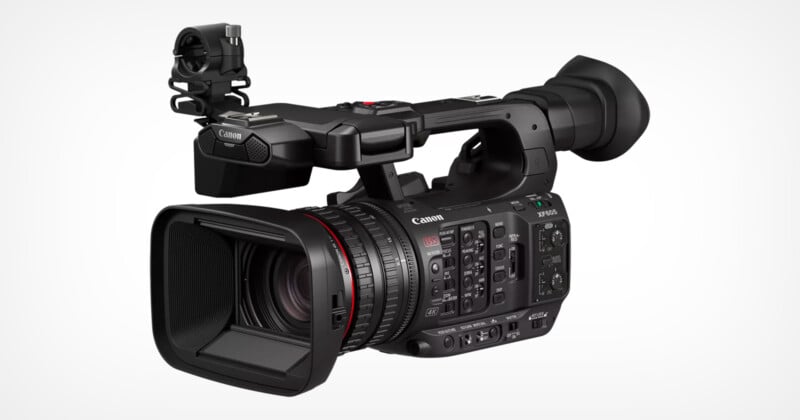 A professional Canon video camera with a large lens and numerous control buttons and dials, designed for high-quality video recording. The camera features a prominent viewfinder and a microphone holder on top.