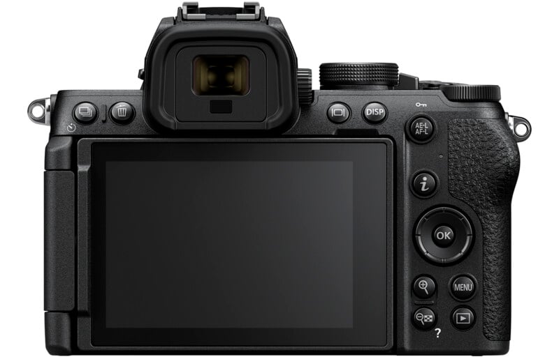 Rear view of a black digital camera showing its LCD screen, control buttons, and viewfinder. The camera features a textured grip on the right side, with various buttons and dials positioned around the screen for settings and adjustments.