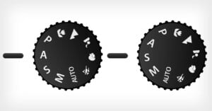 Image of two black camera mode dials. Each dial includes settings like "P," "A," "S," "M," and "AUTO," along with icons for portrait, landscape, macro, and sports modes. The dials are against a light gray background.