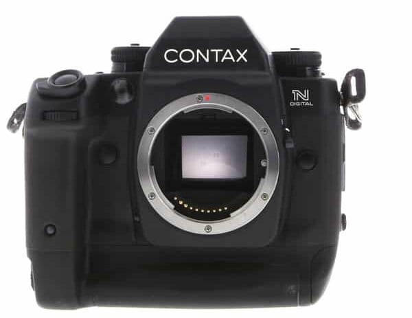 A Contax camera body with no lens attached, displaying the camera mount and sensor. The camera features control dials and buttons and is black with a textured grip. The brand name "Contax" is visible on the top.