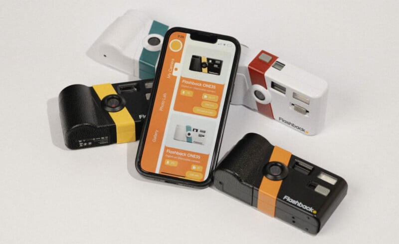 A smartphone displaying a Flashback camera app is surrounded by several compact cameras in different colors: two black with orange stripes, one black with a yellow stripe, and one white with a red stripe.