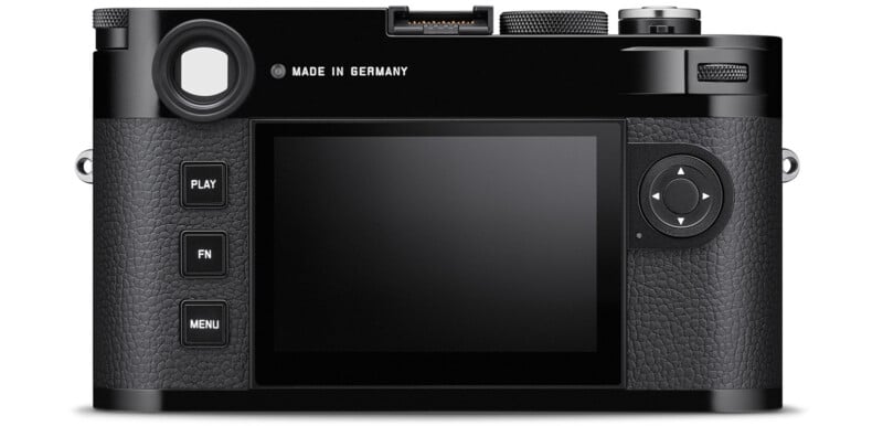 The image shows the back view of a black digital camera with a large display screen, control buttons on the left, a navigation pad on the right, and textured grip surfaces. The camera body is stamped with "Made in Germany.