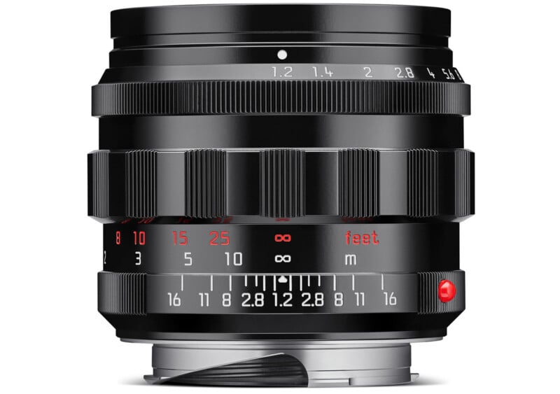 A black camera lens with focal length markings is shown. The lens has various aperture and distance indicators in white and red, with a metallic mount at the base.