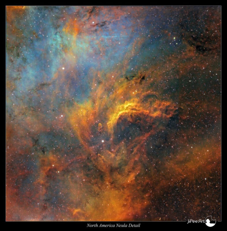 A vibrant image of the North America Nebula, showing swirling patterns of blues, oranges, and greens. The cosmic dust and gas create a colorful, textured scene resembling an abstract painting set against a backdrop of stars.