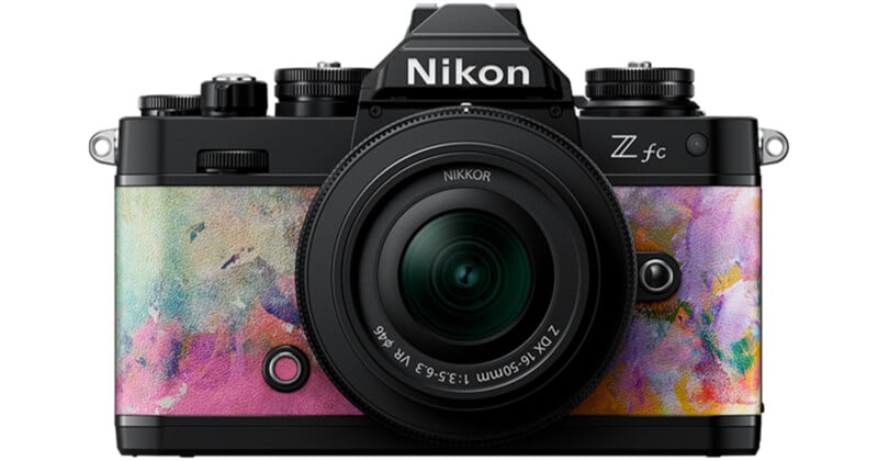 A Nikon Z fc camera with a colorful, artistic front design featuring abstract pastel patterns. The lens is prominently displayed in the center, surrounded by various controls and dials.