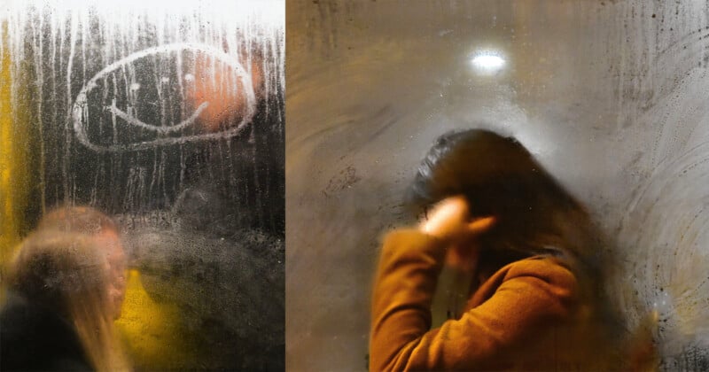 A foggy glass surface with a smiley face drawn in the condensation. On the left, a blurred outline of two people; on the right, a person in a brown jacket adjusting their hair.