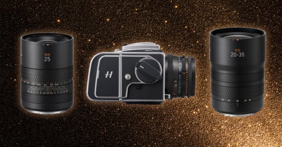 A vintage black camera situated between two modern camera lenses on a sparkling golden background. The lenses are labeled "XCD 25" on the left and "XCD 20-35" on the right.