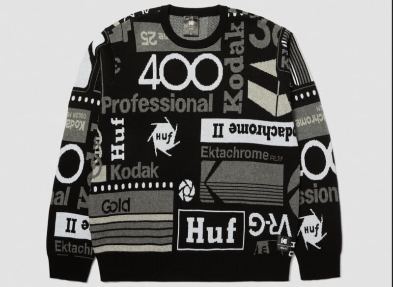 A black-and-white sweater featuring various graphic patterns and words such as "Kodak," "Huf," "Professional," and "400." The design is bold and modern, with a mix of abstract shapes and text blocks.