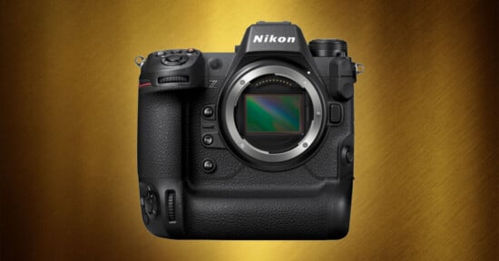 A Nikon mirrorless camera body with a textured grip, prominent buttons, and a lens mount is displayed against a gold, textured background.