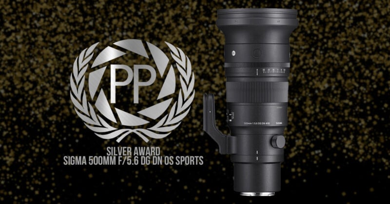 Image of a black Sigma 500mm f/5.6 DG DN OS Sports camera lens displayed against a sparkling background. Next to the lens is a silver award emblem with "PP" in the center. The text reads: "Silver Award Sigma 500mm f/5.6 DG DN OS Sports.