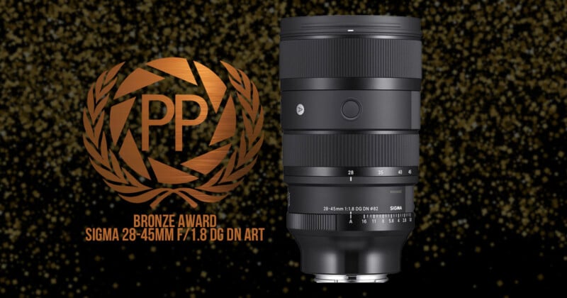 A Sigma 28-45mm F/1.8 DG DN Art lens displayed against a sparkly black background. Next to it is a bronze award emblem that reads "PP Bronze Award.