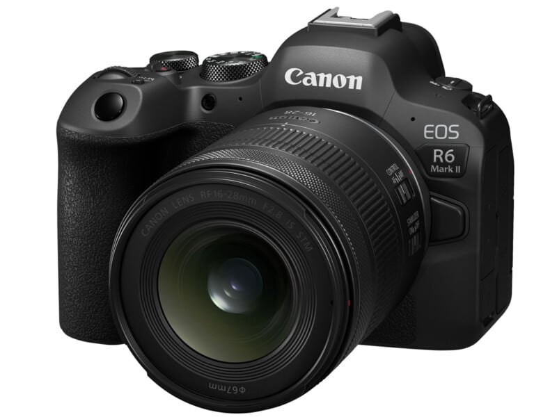 A Canon EOS R6 Mark II camera with a black body and a 16-28mm lens attached, angled to the left. The camera features prominent branding and dial controls on its top surface.