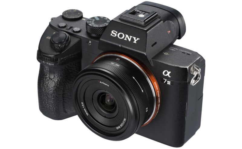 A Sony Alpha A7 III mirrorless camera with a 28-70mm lens attached. The camera is black and features a textured grip, various control dials, and a mounted lens with brand markings visible.