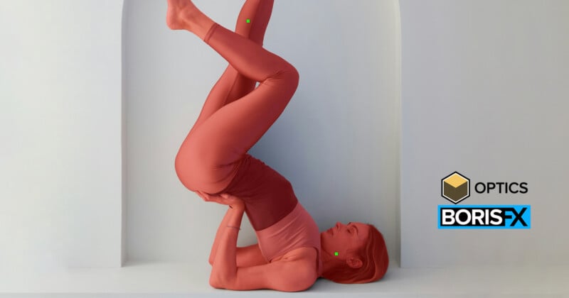 Woman in coral workout attire performs a shoulder stand yoga pose against a white arched wall. Her knees are bent, and she supports her hips with her hands. Logos for Optics and Boris FX are visible on the right side.