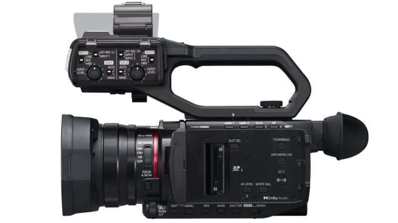 Side view of a professional video camera with various control buttons, a side handle, and an eyepiece. It features a lens on the left, multiple input ports, and an SD card slot. The camera is black with a compact, ergonomic design.