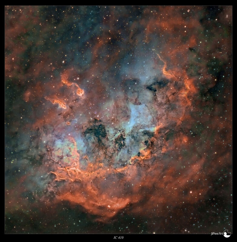 A vivid astronomical image of the IC 410 nebula. It shows swirling clouds of gas in blue and orange hues against a backdrop of stars. The colors form intricate patterns, showcasing celestial beauty within the universe.