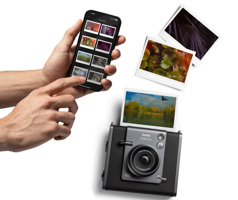 Hands hold a smartphone displaying photo thumbnails. Nearby, an instant camera is placed on a surface, with several colorful printed photos of nature scenes scattered around it.