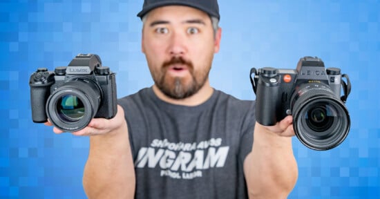 A person in a cap holds two cameras in their hands against a blue pixelated background. They have an expression of surprise or excitement. The camera on the left is a Lumix, and on the right is a Leica.