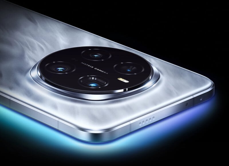 Close-up of a modern smartphone featuring a large circular rear camera module with multiple lenses. The phone has a sleek, metallic finish and a glowing edge, set against a dark background.