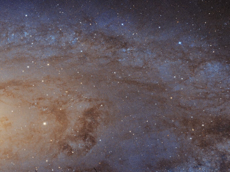 A stunning image of the Andromeda Galaxy, showcasing a dense field of stars and cosmic dust with a bright, glowing center. The galaxy's spiral arms are visible, creating a swirling pattern of light and dark.