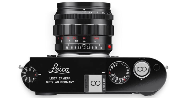 Top view of a Leica M11 camera, featuring a black body with a lens attached. The camera displays various dials and branding that reads "Leica Camera Wetzlar Germany.