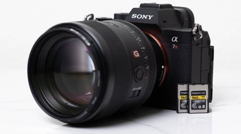 A Sony Alpha 7R camera is shown with a lens attached. Two ProGrade Digital 960 GB memory cards are positioned upright next to it. The background is white, giving a clean and minimalist look.