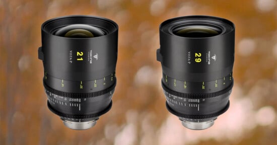 Two camera lenses with black exteriors and green and yellow markings. The lens on the left is labeled "21" and the lens on the right is labeled "29." Both are set against a blurred brown and orange background.