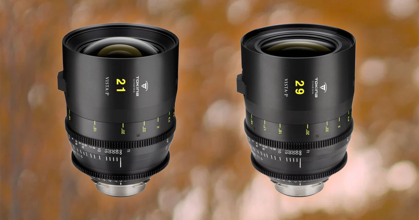 Two camera lenses with black exteriors and green and yellow markings. The lens on the left is labeled "21" and the lens on the right is labeled "29." Both are set against a blurred brown and orange background.