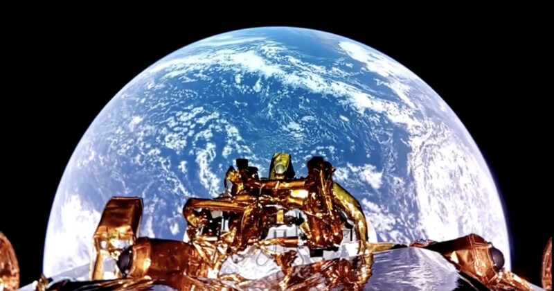 A view of Earth from space, showing the planet in vivid blue and white colors. In the foreground, a spacecraft with metallic, golden reflective surfaces is visible, capturing the moment from orbit.